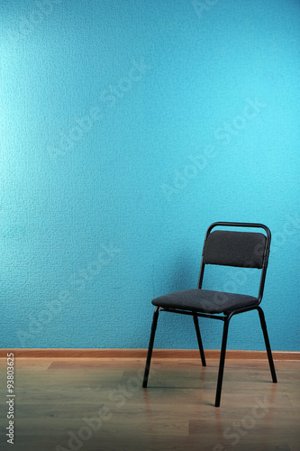 Black chair on blue wall background