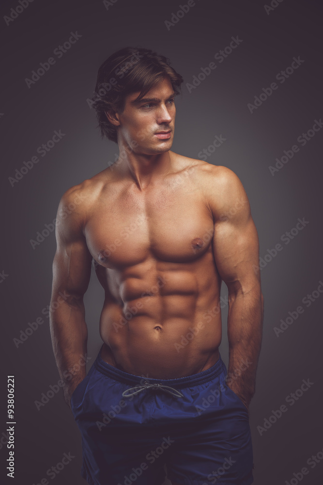 Fototapeta premium Shirtless muscular man in blue shorts.