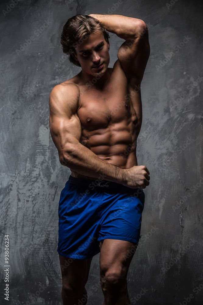 Fototapeta premium Shirtless muscular man in blue shorts.