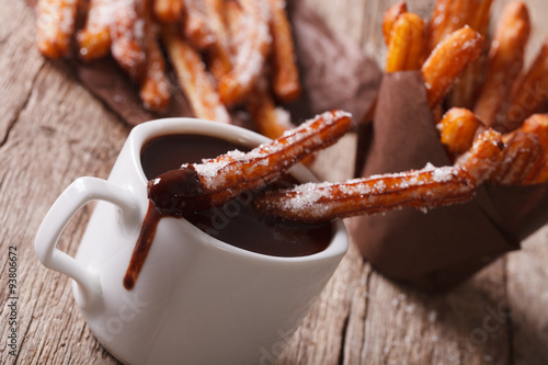 churros with a cup of hot chocolate on a table. Horizontal

