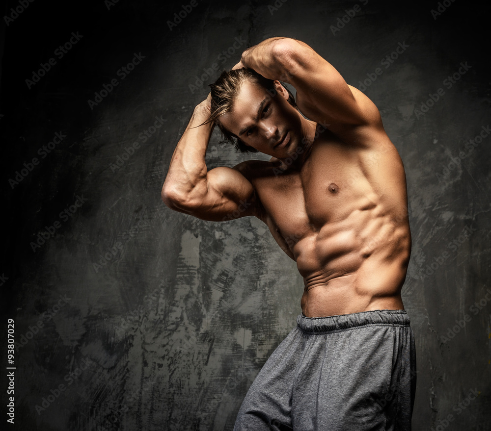 Fototapeta premium Shirtless muscular guy posing in studio.