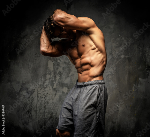 Shirtless muscular guy posing in studio.