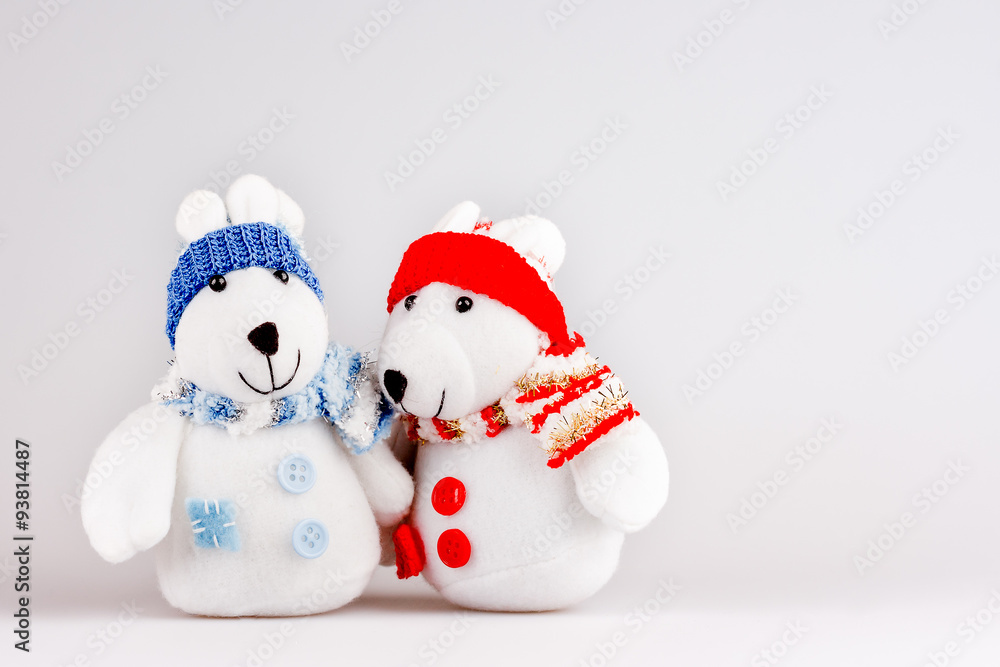Pair of cute plush rabbits in warm clothes. Sweet couple of toys in scarfs and caps. Christmas background with empty space for text.