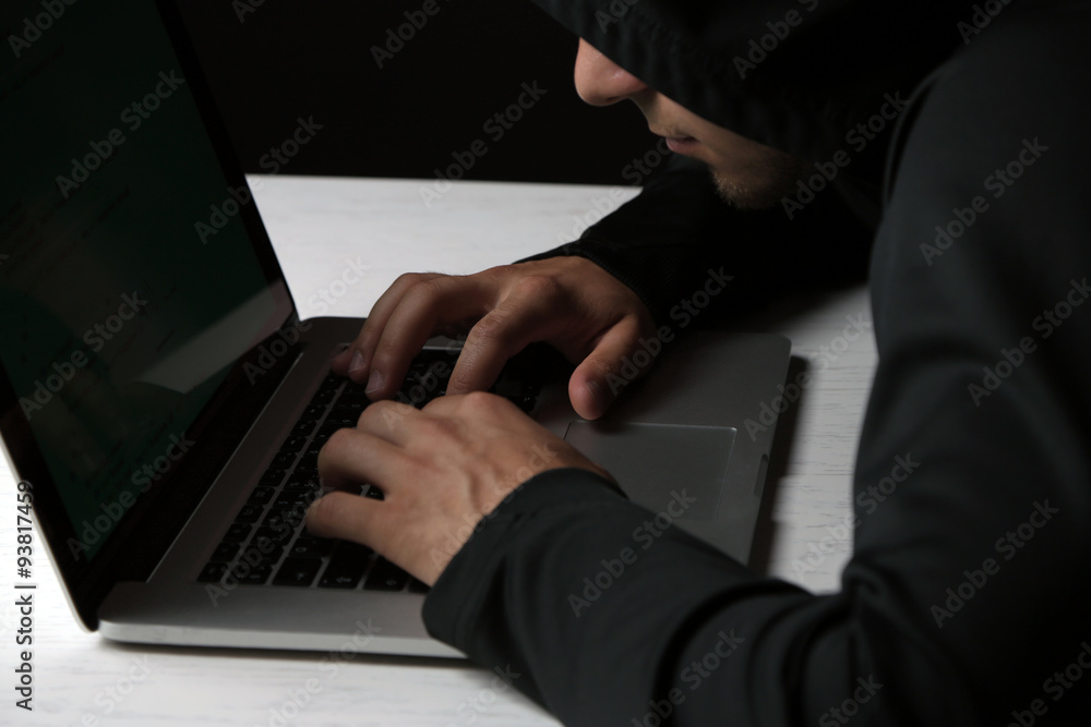Hacker with computer and laptop on colorful dark background Hacker with computer and laptop on colorful dark background