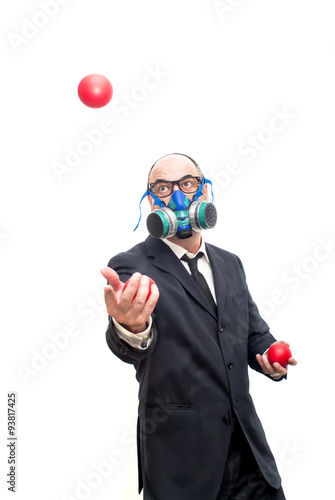 Businessman with gas mask  that is juggling with a red balls