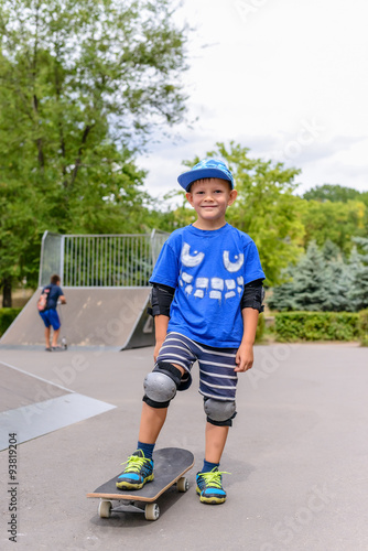 Small boy standing on his skateboard