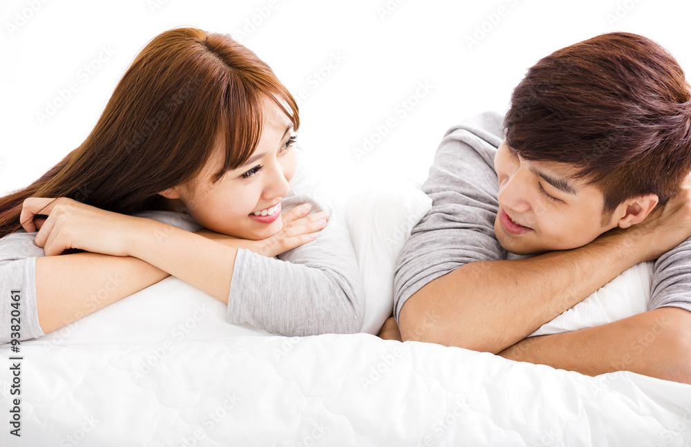 happy young couple lying in a bed