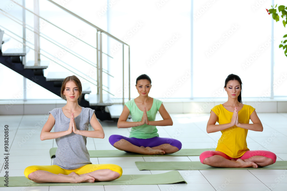 Three young women do yoga