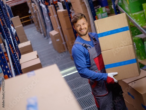 Porter carrying boxes in a warehouse