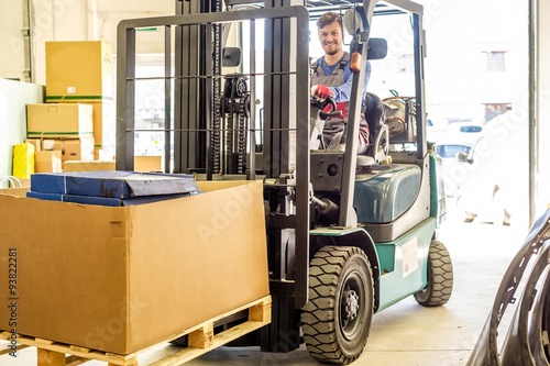Man driving forklift truck on a warehouse photo