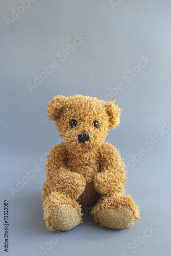 Brown teddy bear on grey background