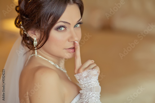 Beautiful young woman in white dress preparing herself to wedding 