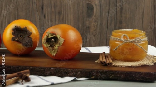 Fresh ripe persimmon on a wooden table.