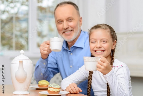 Grandfather and little girl having tea party 