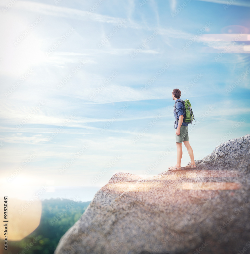 Portrait of a young man with backpack on the rock. Visual