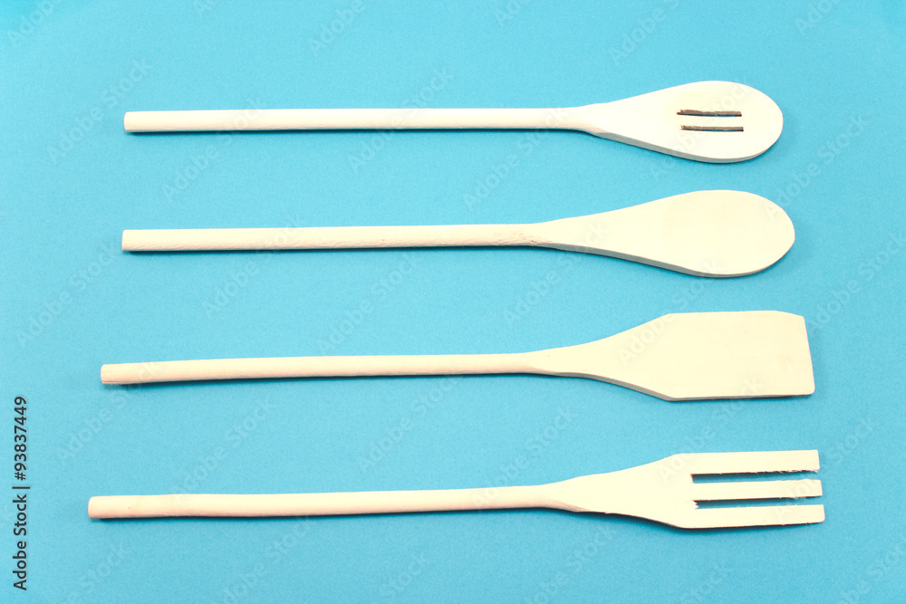 Wooden cutlery set isolated on blue background Wooden cutlery set isolated on blue background