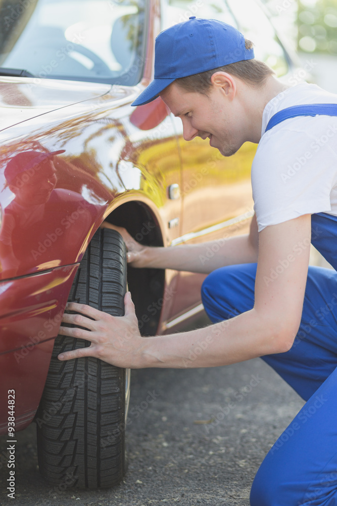 Automechaniker prüft Reifen