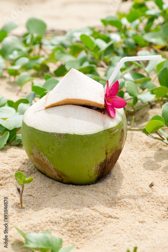 a Coconut Water with Straw and Flower at the Beach