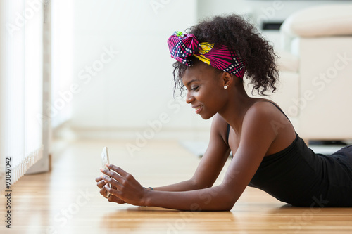 African American woman sending a text message on a mobile phone photo