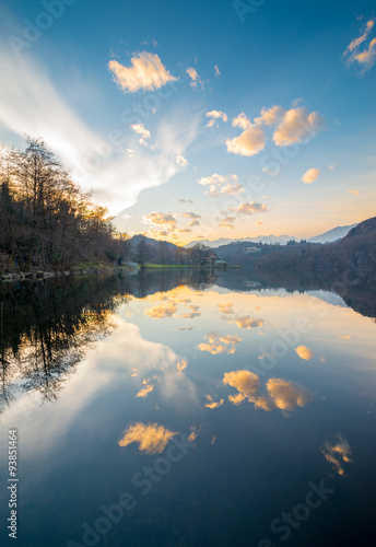 Fototapeta Naklejka Na Ścianę i Meble -  Calm water of Sirio Lake in Piedmont, dusk light, cloudy sky reflections