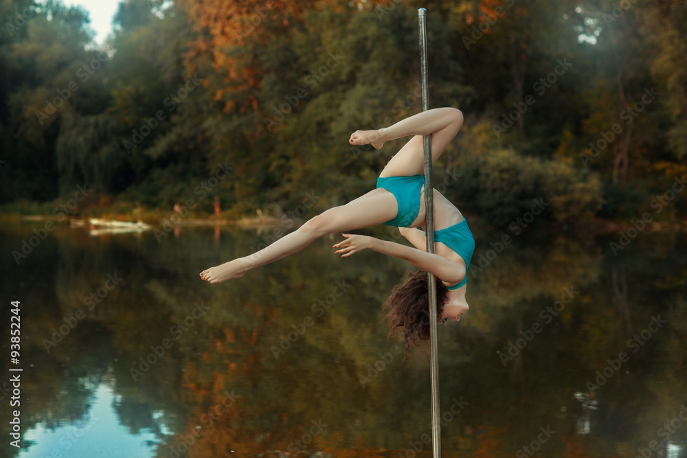 Girl revolves on the pole for dancing performing tricks.
