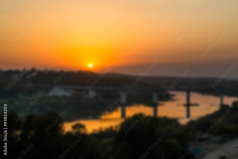 Blurred background sunset over the river with a bridge