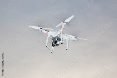 Fototapeta Naklejka Na Ścianę i Meble -  White drone hovering in a bright grey sky