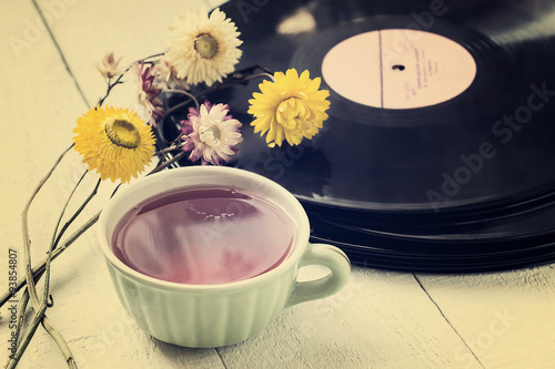 Cup of tea, old vinyl records and dry flowers photo