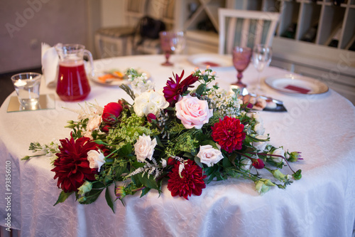 interior of the restaurant,  large table laid for  Banquet, decorated in Burgundy tones