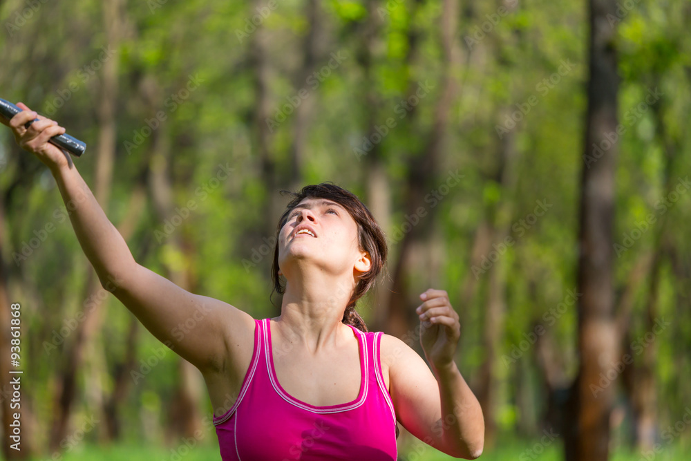 Pretty, young woman playing badminton in a city park on a lovely summer day Pretty, young woman playing badminton in a city park on a lovely summer day