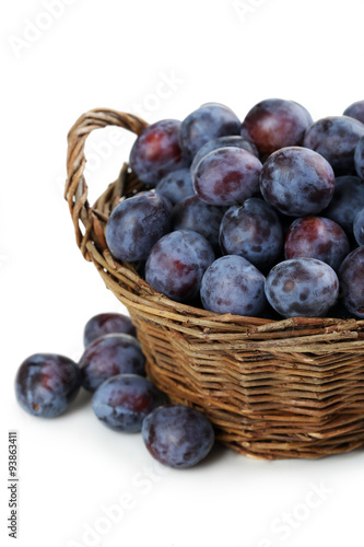 Fresh plums in basket on a white background