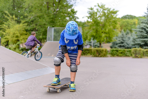Small boy at the skate park in summer
