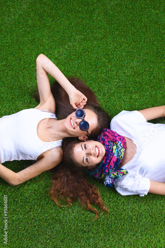 Attractive young girls relaxing on grass.