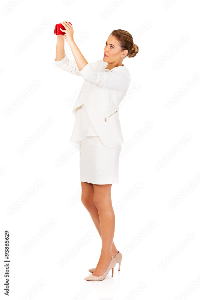 Shocked businesswoman looking into her empty wallet Shocked businesswoman looking into her empty wallet