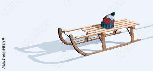 Wooden sled and hat on snow photo
