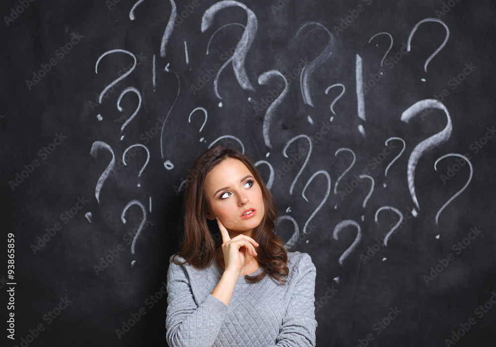 Young girl with question mark on a gray background Young girl with question mark on a gray background