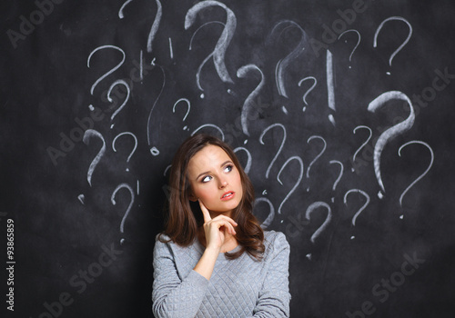 Young girl with question mark on a gray background