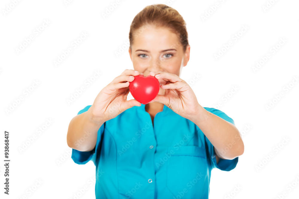 Young female doctor or nurse holding heart toy Young female doctor or nurse holding heart toy