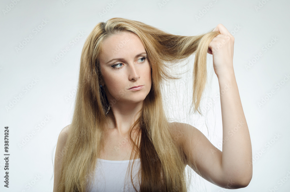Girl looks at the tips of the cross-section of hair Girl looks at the tips of the cross-section of hair