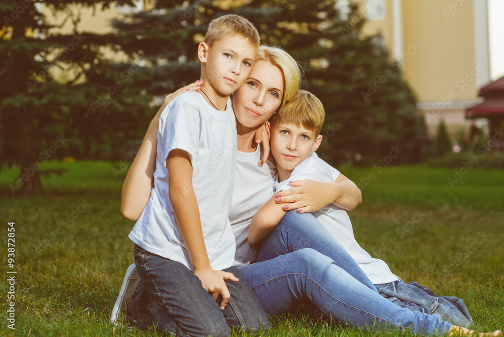 Fototapeta premium Happy family sitting on the grass in summer. Picnic concept