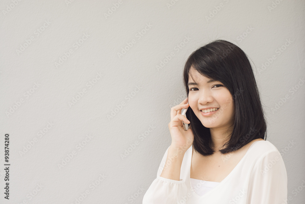 Beautiful asian young woman talking on Mobile Phone, over concrete wall Beautiful asian young woman talking on Mobile Phone, over concrete wall
