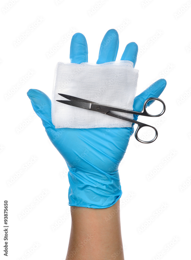 Hands of a medic wearing a blue latex gloves with surgical sciss Hands of a medic wearing a blue latex gloves with surgical sciss