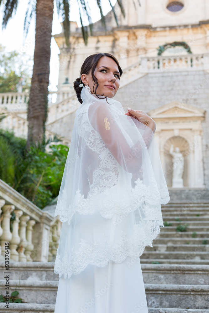 Fototapeta premium Beautiful bride outdoors posing on the steps
