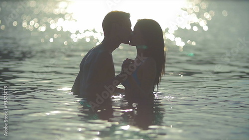8 in 1 video! The couple (pair) walk on the beach and hug and kiss in the water with sunlight reflection. Real time and slow motion capture. photo