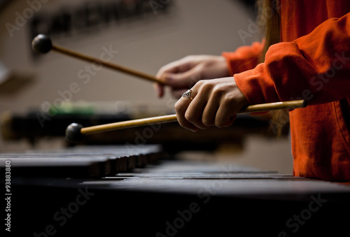 Hands of the girl playing the xylophone in dark colors photo