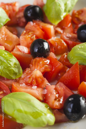 Salad dish with tomato, olives and basil