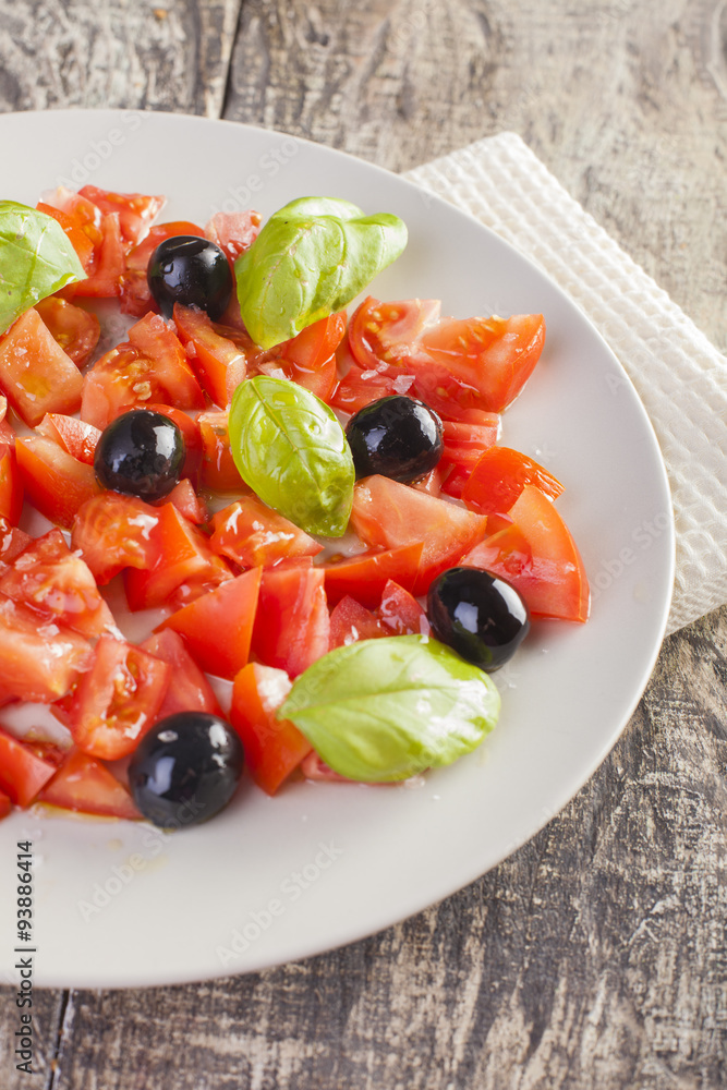 Salad dish with tomato, olives and basil Salad dish with tomato, olives and basil