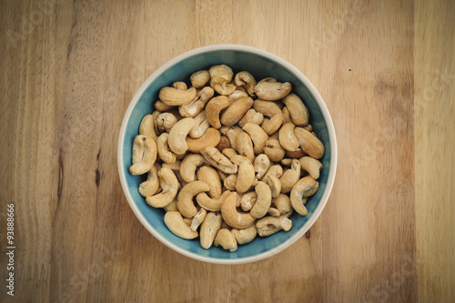 Cashew nuts on bowl on Wood desk background