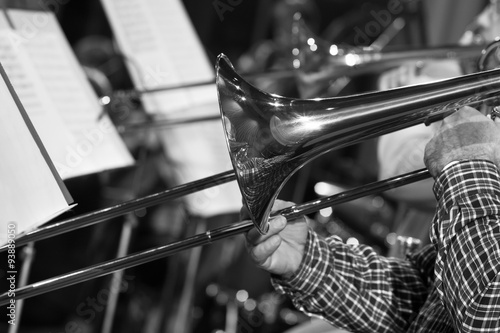 Hands of man playing the trombone in black and white