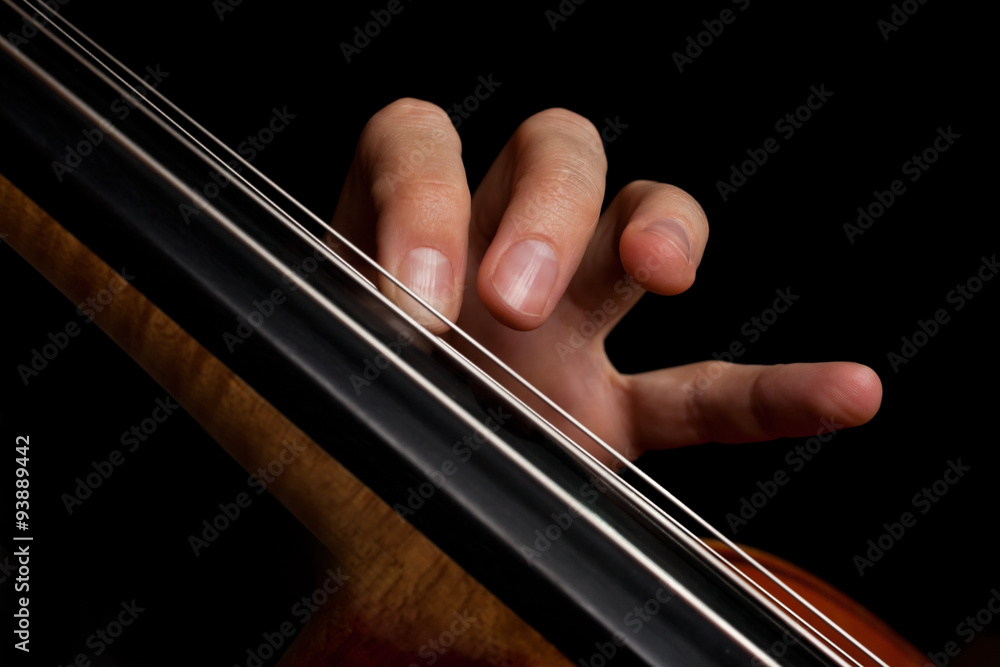 The fingers on the strings of the cello on a black background The fingers on the strings of the cello on a black background